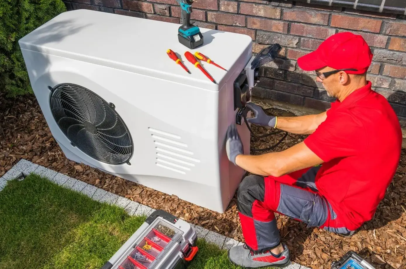 A man in red shirt fixing air conditioner.